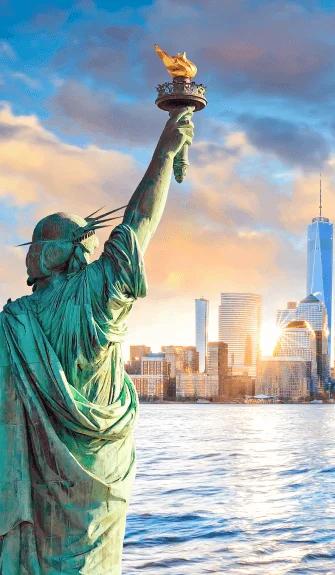 Statue of Liberty and NYC skyline at sunset – Fab Holidays, the best travel agency in Delhi.