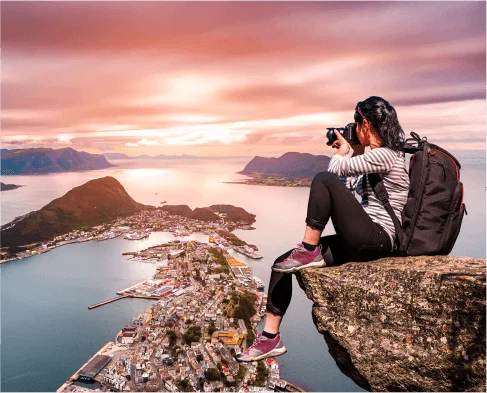 Solo traveler capturing a scenic mountain view planned by the best travel agency in Delhi