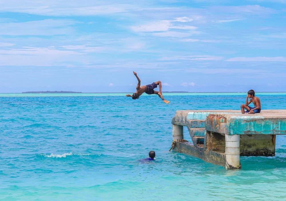 Tourists enjoying a dive into crystal-clear waters in Maldives – Maldives Tour Package India