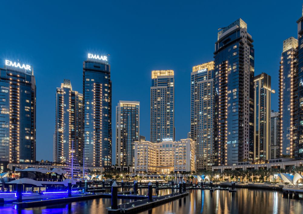 Night view of Dubai Marina skyscrapers with yachts, part of a Dubai city tour package experience