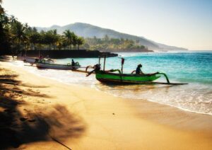 Traditional fishing boat on a tranquil Bali beach at sunrise – Bali Tour Package from Delhi