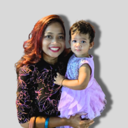 Smiling woman holding a young child, both dressed beautifully, after a successful Singapore trip organized by Fab Holidays.