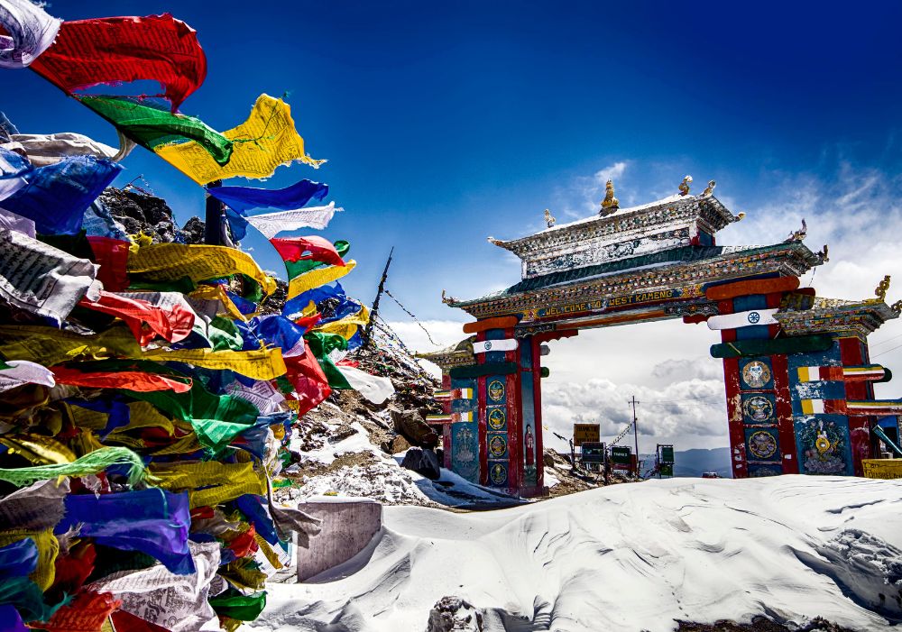 Tawang Tour Package – Colorful prayer flags and Sela Pass gate in snow-covered Arunachal Pradesh