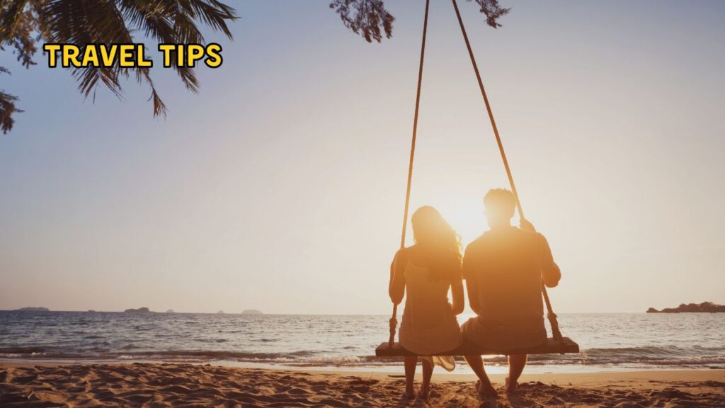 Couple enjoying sunset on a beach swing – travel tips for the best honeymoon places in India in December by Fab Holidays.
