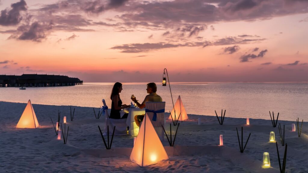 Romantic beach dinner setup at sunset – one of the best honeymoon places in India planned by Fab Holidays, the best travel agency in Delhi