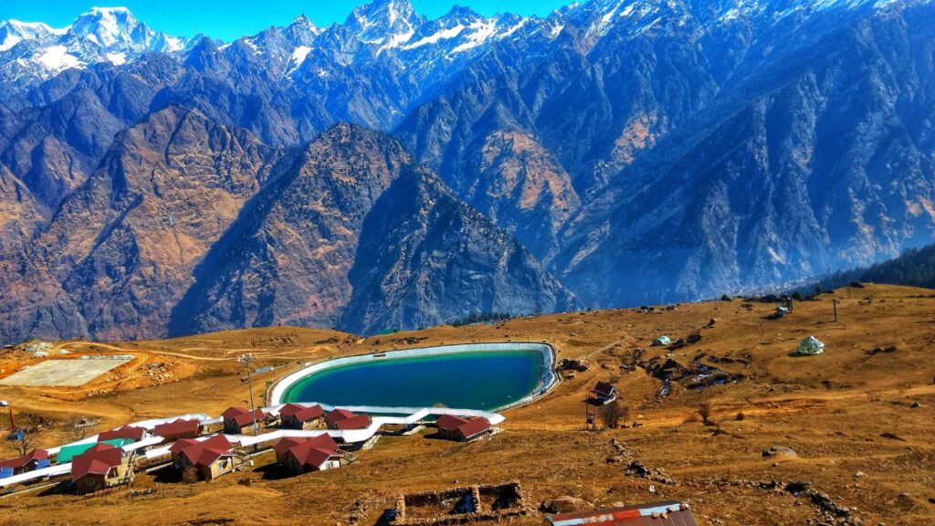 Panoramic view of Auli’s snow-capped mountains and serene lake, one of the best honeymoon places in India in December, planned by Fab Holidays.
