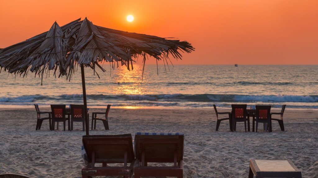 Romantic sunset view on a Goa beach with chairs and umbrellas, one of the best honeymoon places in India in December, organized by Fab Holidays.